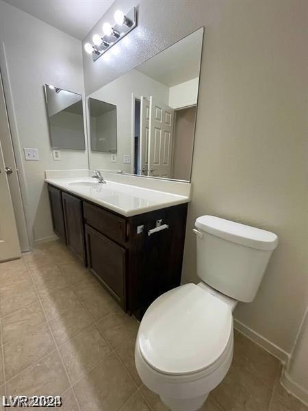 bathroom with vanity, toilet, and tile patterned flooring