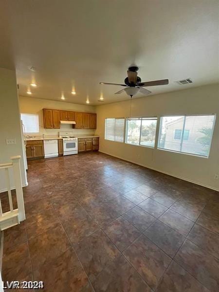 unfurnished living room featuring dark tile patterned floors and ceiling fan