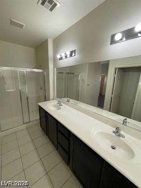 bathroom with tile patterned floors, vanity, and an enclosed shower