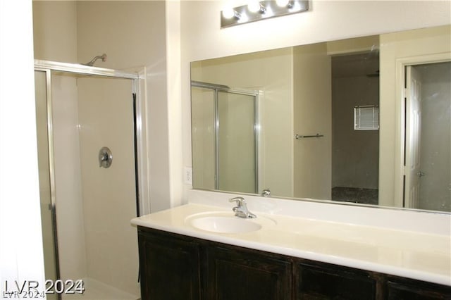 bathroom with vanity and a shower with door