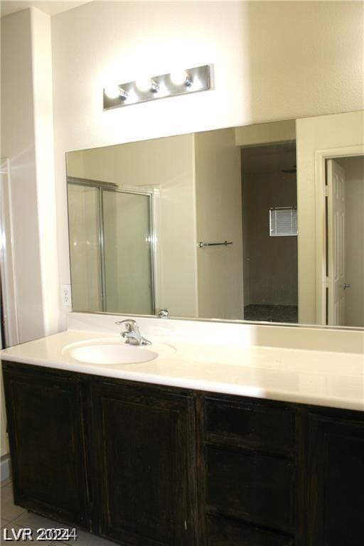 bathroom featuring vanity, tile patterned floors, and walk in shower