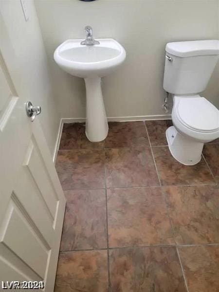 bathroom featuring toilet and tile patterned flooring