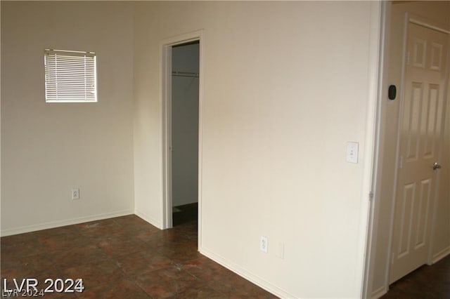 unfurnished bedroom featuring a walk in closet and a closet