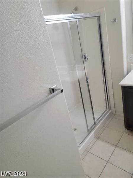 bathroom featuring walk in shower, tile patterned floors, and vanity