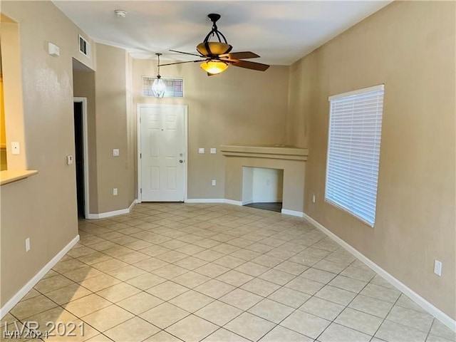 unfurnished living room with ceiling fan and light tile floors