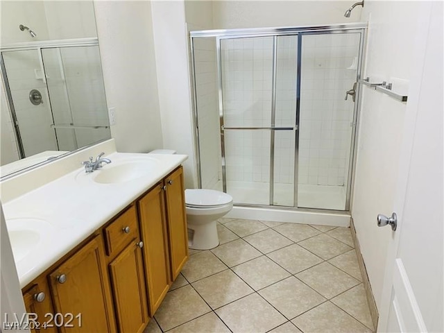 bathroom with tile flooring, walk in shower, dual vanity, and toilet