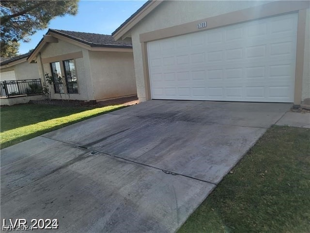 exterior space with a garage and a lawn