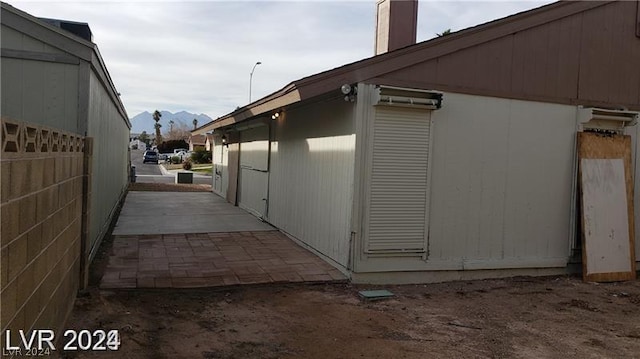 view of home's exterior featuring a mountain view and a patio