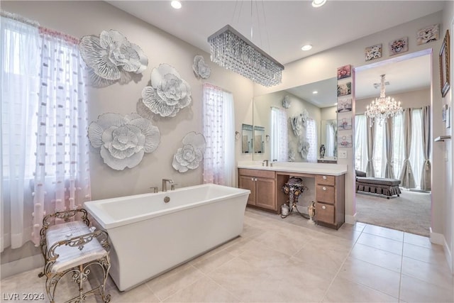 bathroom featuring tile patterned floors, vanity, a bath, and a wealth of natural light