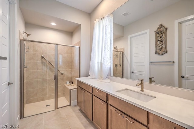 bathroom featuring vanity, a shower with door, and tile patterned flooring