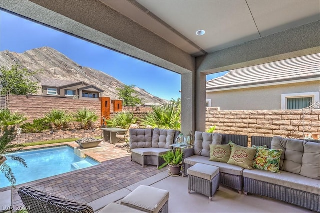 view of patio with an outdoor living space, a mountain view, and a fenced in pool