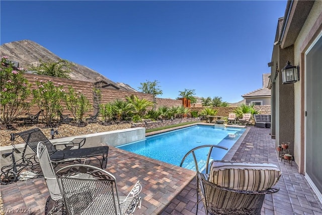 view of pool featuring a mountain view and a patio area