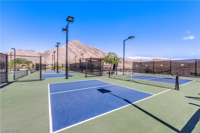 view of sport court with a mountain view and basketball hoop