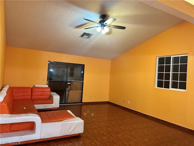 unfurnished living room featuring ceiling fan, lofted ceiling, dark hardwood / wood-style flooring, and a textured ceiling