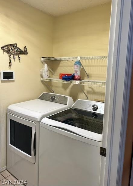 washroom with washer and dryer and light tile patterned floors