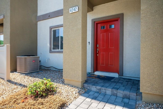 view of exterior entry with central air condition unit