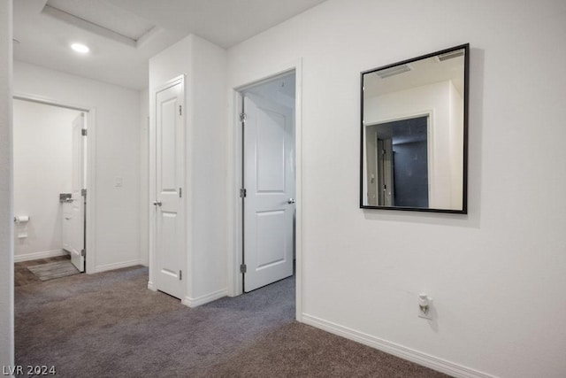 hallway with dark colored carpet