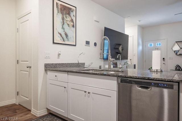 kitchen with dark stone countertops, dishwasher, sink, and white cabinets