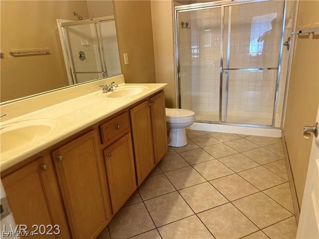 bathroom with walk in shower, tile flooring, dual vanity, and toilet