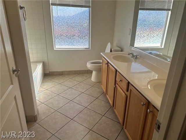 bathroom with tile floors, plenty of natural light, double vanity, and toilet