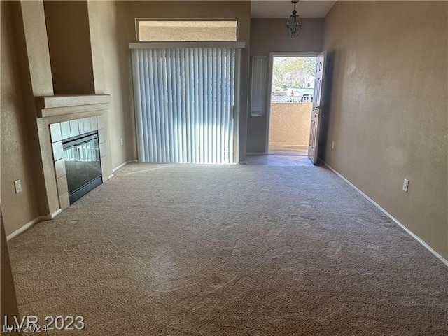 unfurnished living room with carpet and a tile fireplace