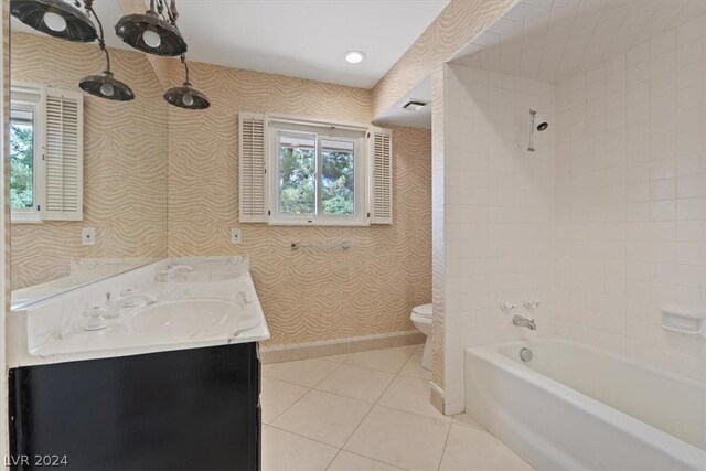 full bathroom featuring tile patterned floors, vanity, tiled shower / bath combo, and toilet