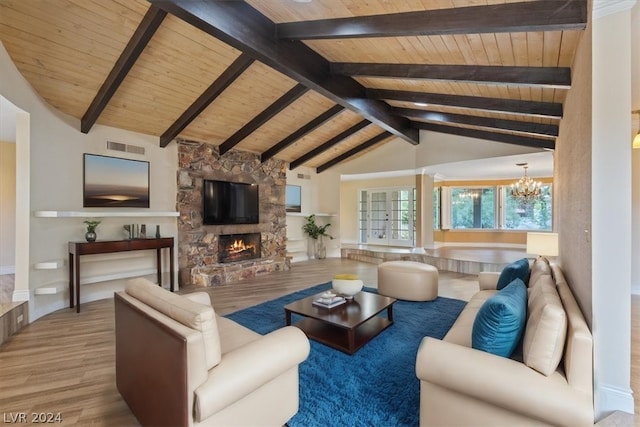 living room featuring beam ceiling, a chandelier, light wood-type flooring, wood ceiling, and a stone fireplace