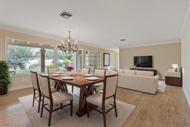 dining room featuring a notable chandelier, light hardwood / wood-style floors, and ornamental molding