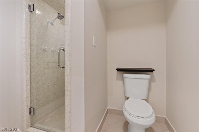 bathroom with tile patterned floors, a shower with shower door, and toilet