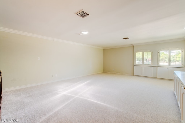 spare room featuring crown molding and light carpet