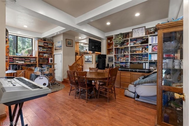 dining space featuring beam ceiling and light hardwood / wood-style flooring