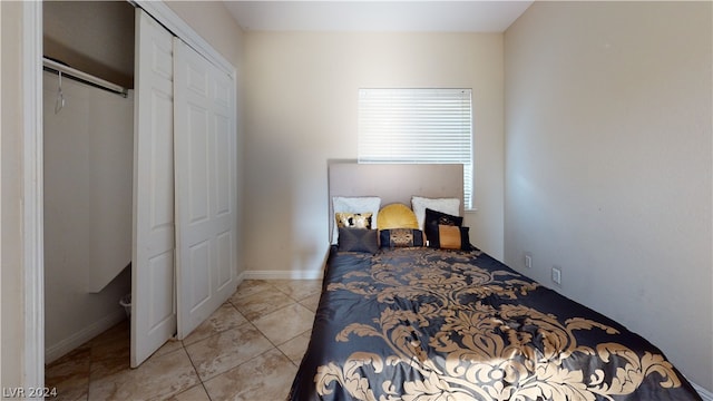 bedroom featuring light tile patterned floors and a closet