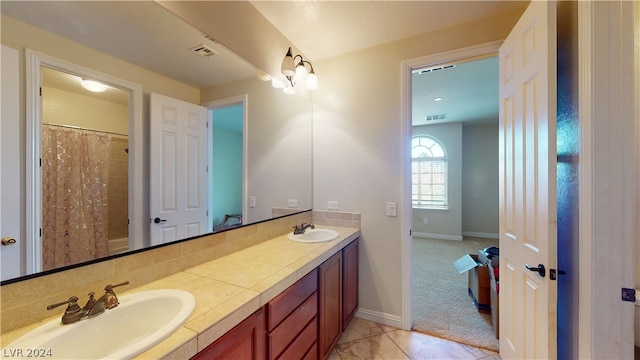 bathroom featuring tile patterned flooring, vanity, and curtained shower