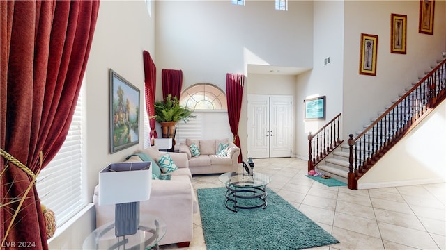 living room featuring a towering ceiling and light tile patterned flooring