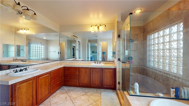 bathroom with tile patterned floors, a shower with shower door, and vanity