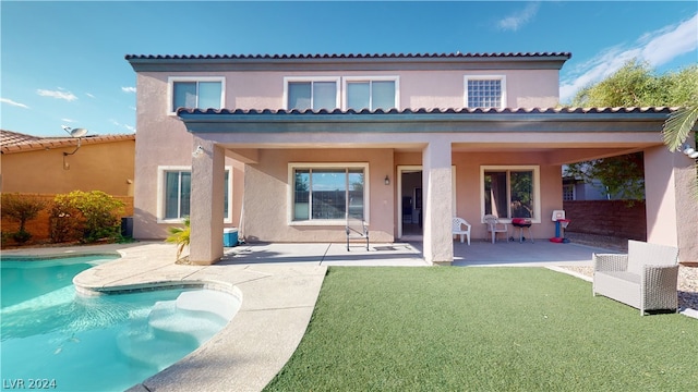 back of house with a yard and a patio