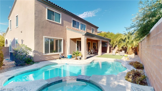 back of house with a pool with hot tub and a patio