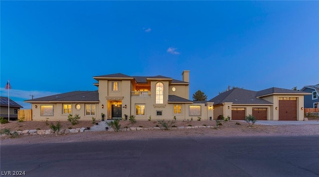 view of front of property featuring a balcony and a garage