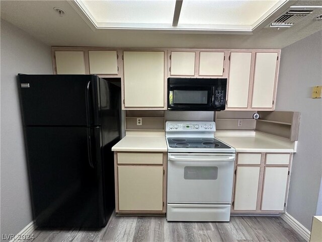 kitchen featuring white cabinetry, black appliances, and light wood-type flooring