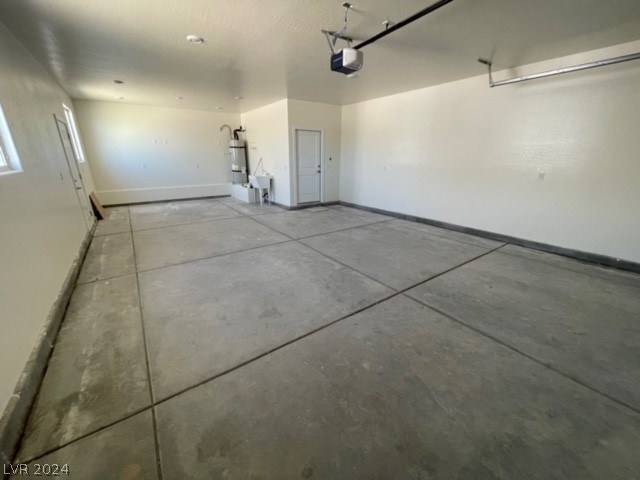 garage featuring sink, a garage door opener, and gas water heater