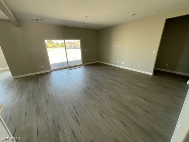 empty room with wood-type flooring and beam ceiling