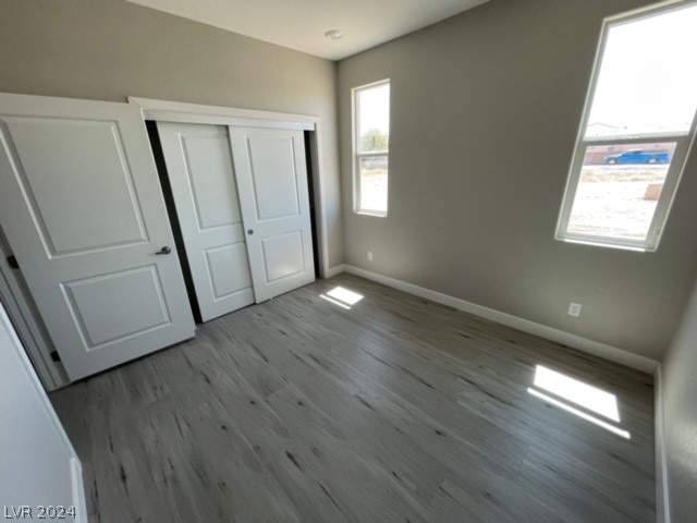 unfurnished bedroom with a closet and hardwood / wood-style floors