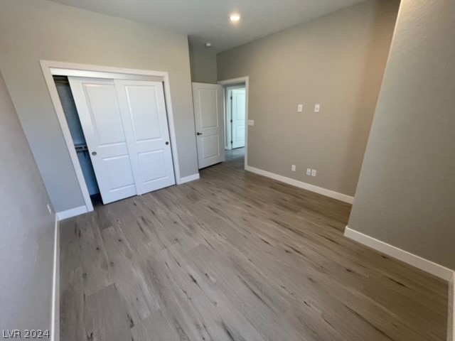 unfurnished bedroom with hardwood / wood-style flooring and a closet