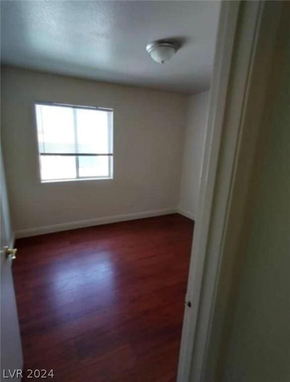 unfurnished room featuring dark hardwood / wood-style flooring