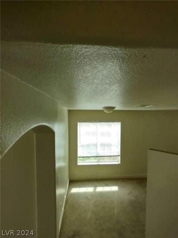 bonus room featuring a textured ceiling