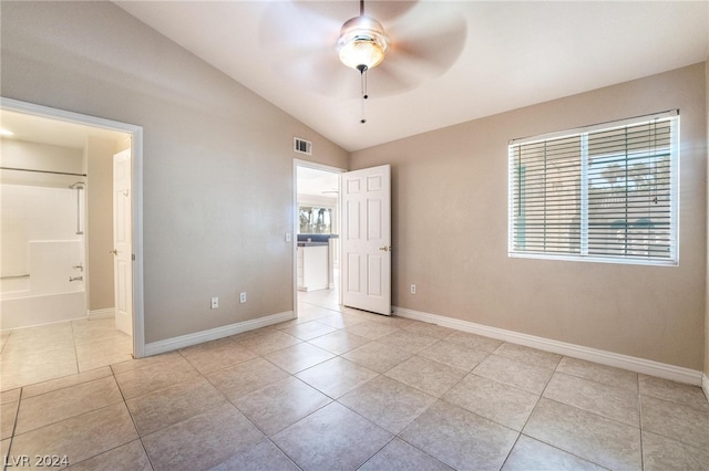 empty room featuring light tile patterned flooring, ceiling fan, and vaulted ceiling