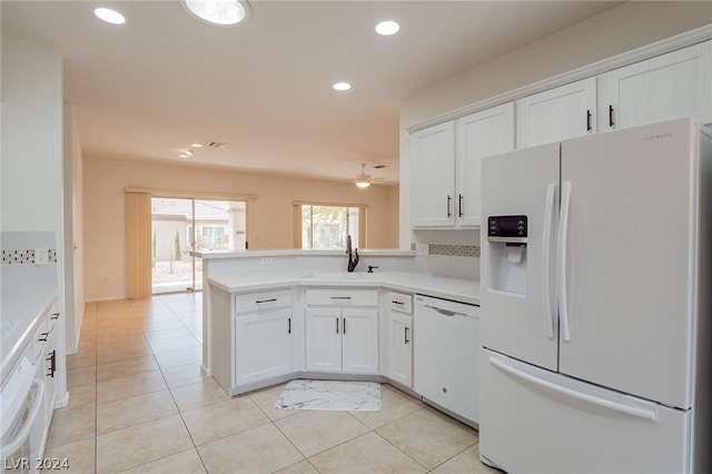 kitchen featuring kitchen peninsula, white appliances, white cabinetry, and sink