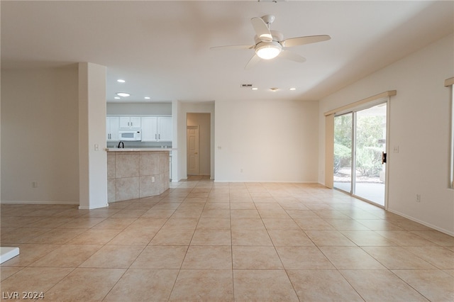 unfurnished living room with light tile patterned floors and ceiling fan