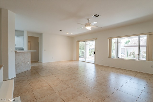 unfurnished room with ceiling fan and light tile patterned floors