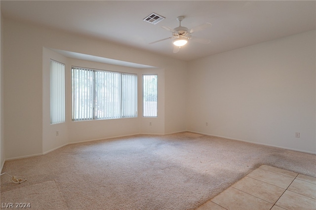 empty room featuring light colored carpet and ceiling fan